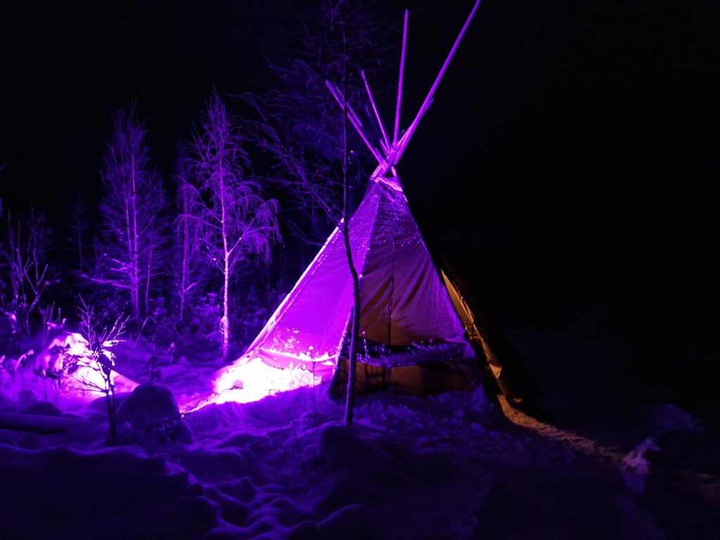 Violetiksi valaista kota lumisessa maisemassa